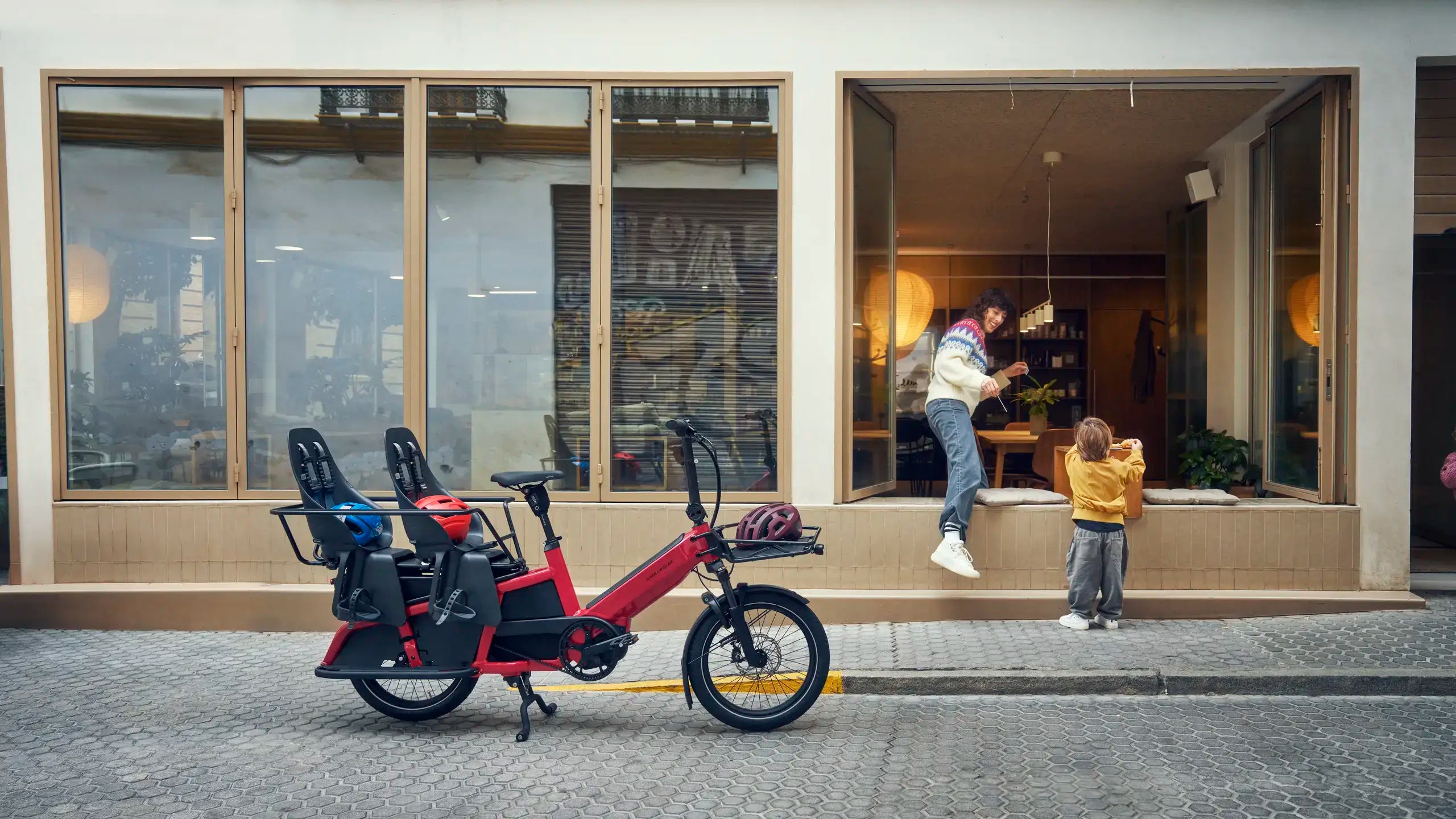Riese & Müller Multitinker Vario Familienrad mit Kindersitzen vor einem Gebäude