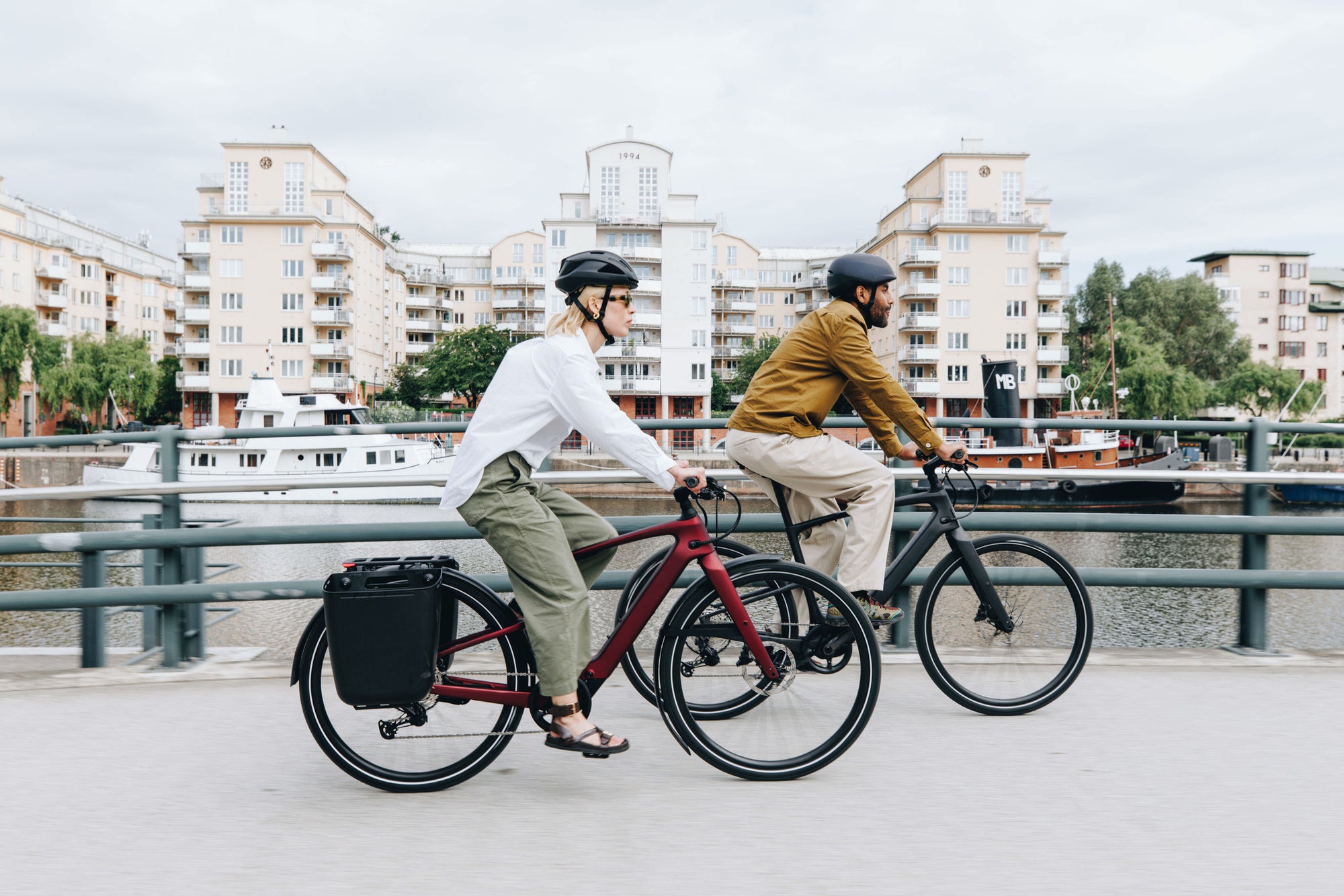 Zwei Personen fahren mit Specialized Fahrrädern über eine Brücke am Wasser